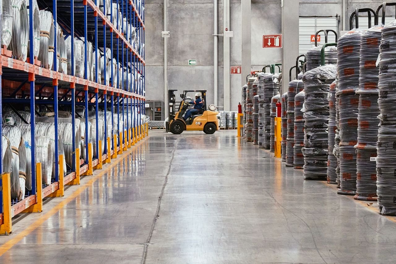 services-06 A forklift operates in an industrial warehouse with stacked goods. Efficient distribution setting.